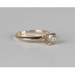 A gold and diamond single stone ring, claw set with a circular cut diamond within a raised