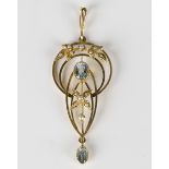 A gold, aquamarine and seed pearl pendant in a pierced openwork design with foliate motifs, detailed