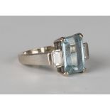 An 18ct white gold, aquamarine and diamond three stone ring, claw set with the cut cornered