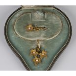 A gold and seed pearl pendant and matching brooch, circa 1900, the pendant designed as three leaves,