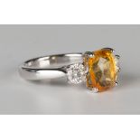 A white gold, intense yellow sapphire and diamond ring, claw set with an oval cut intense yellow