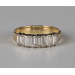 A gold and diamond half-hoop ring, mounted with a row of nine baguette diamonds, detailed '18ct',
