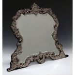 An Edwardian silver mounted dressing table mirror, the bevelled plate within a silver frame,