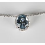 A white gold, aquamarine and diamond pendant necklace, claw set with an oval cut aquamarine within a