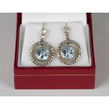 A pair of gold, aquamarine and diamond pendant earrings, each swing centre collet set with a