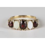 A 9ct gold, opal and garnet five stone ring, mounted with two oval opals alternating with three oval
