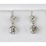 A pair of white gold and diamond pendant earrings, each drop collet set with a circular cut