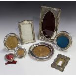 A George V silver mounted rectangular photograph frame with oval aperture and bead and reel borders,