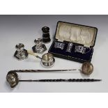 A George V silver three-piece condiment set, Birmingham 1924, cased, two silver punch ladles with