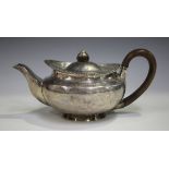 A George III silver teapot of squat circular form with gadrooned rim and hinged lid, London 1817,