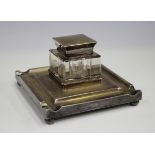 A George V silver inkstand of square form with pen depression borders, fitted with a glass inkwell