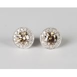 A pair of 18ct white gold, fancy brown diamond and diamond cluster earrings, each claw set with a