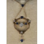 A gold, diamond and sapphire pendant necklace, circa 1910, in a circular openwork design, mounted