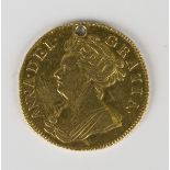 An Anne guinea 1702, pierced with a hole (the obverse badly scratched).Buyer’s Premium 29.4% (
