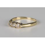 A gold and diamond three stone ring, claw set with a row of circular cut diamonds, the principal