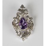 A white gold, amethyst and diamond pendant in a pierced openwork design, mounted with the pear