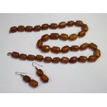 A single row necklace of vari-coloured opaque graduated barrel shaped butterscotch coloured amber