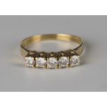 A gold and diamond five stone ring, mounted with a row of circular cut diamonds, detailed '750',