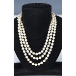 A three row necklace of cultured pearls on a 9ct gold, seed and cultured pearl set clasp, Birmingham
