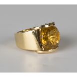 A French 18ct gold and citrine wide band ring, mounted with a circular cut citrine between half-