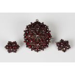 A Bohemian garnet pendant brooch of shaped oval form, the back glazed with a locket compartment,