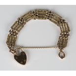 A gold decorated bar and plain oval link gate bracelet, length 18.5cm, with a gold plain heart