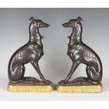 A pair of late 19th century brown patinated cast iron doorstop models of seated greyhounds with