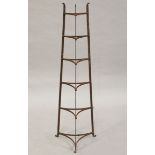 An early 20th century wrought iron six-tier pan rack of waisted triangular form, height 125cm.