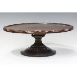 A George V oak lazy Susan with partially chamfered rim, raised on a turned pedestal, height 18cm,