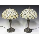 A pair of modern Tiffany style table lamps with leaded glass shades and patinated metal bases,