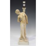 An early 20th century carved alabaster figure of a young nude female, standing in a demure pose