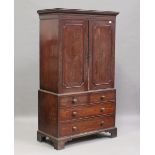 An early Victorian mahogany linen press, the dentil moulded pediment above a pair of panelled