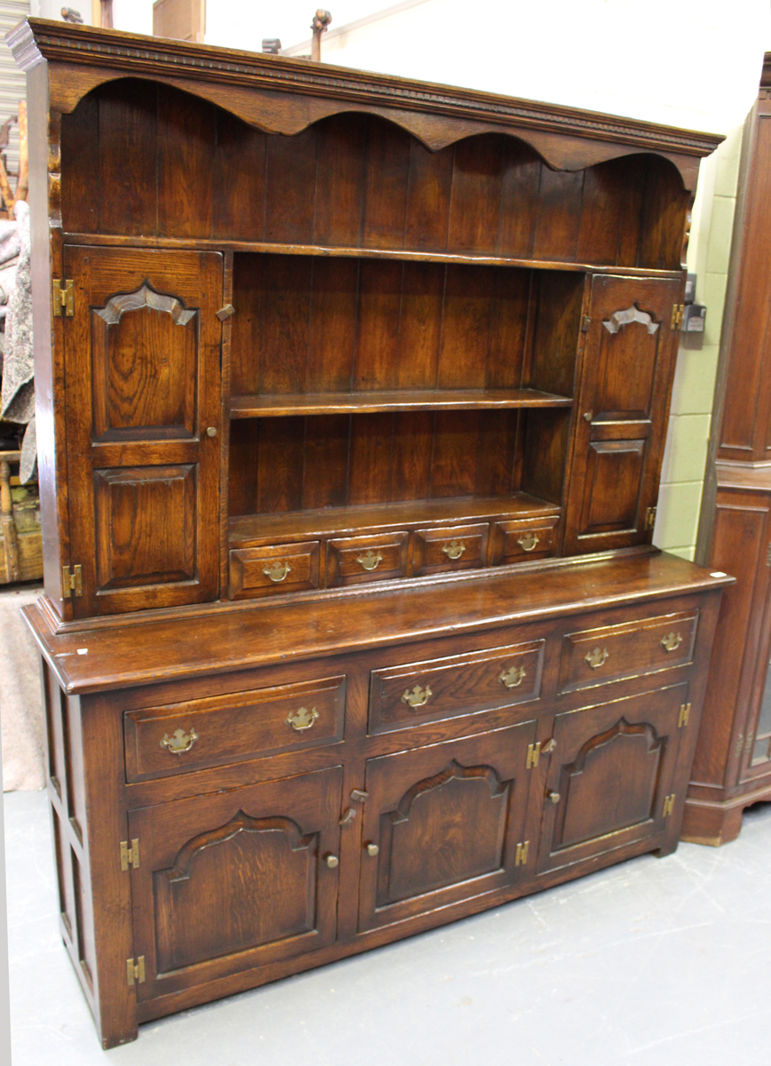 A 20th century reproduction oak dresser, the shelf back above drawers and cupboards, on stile