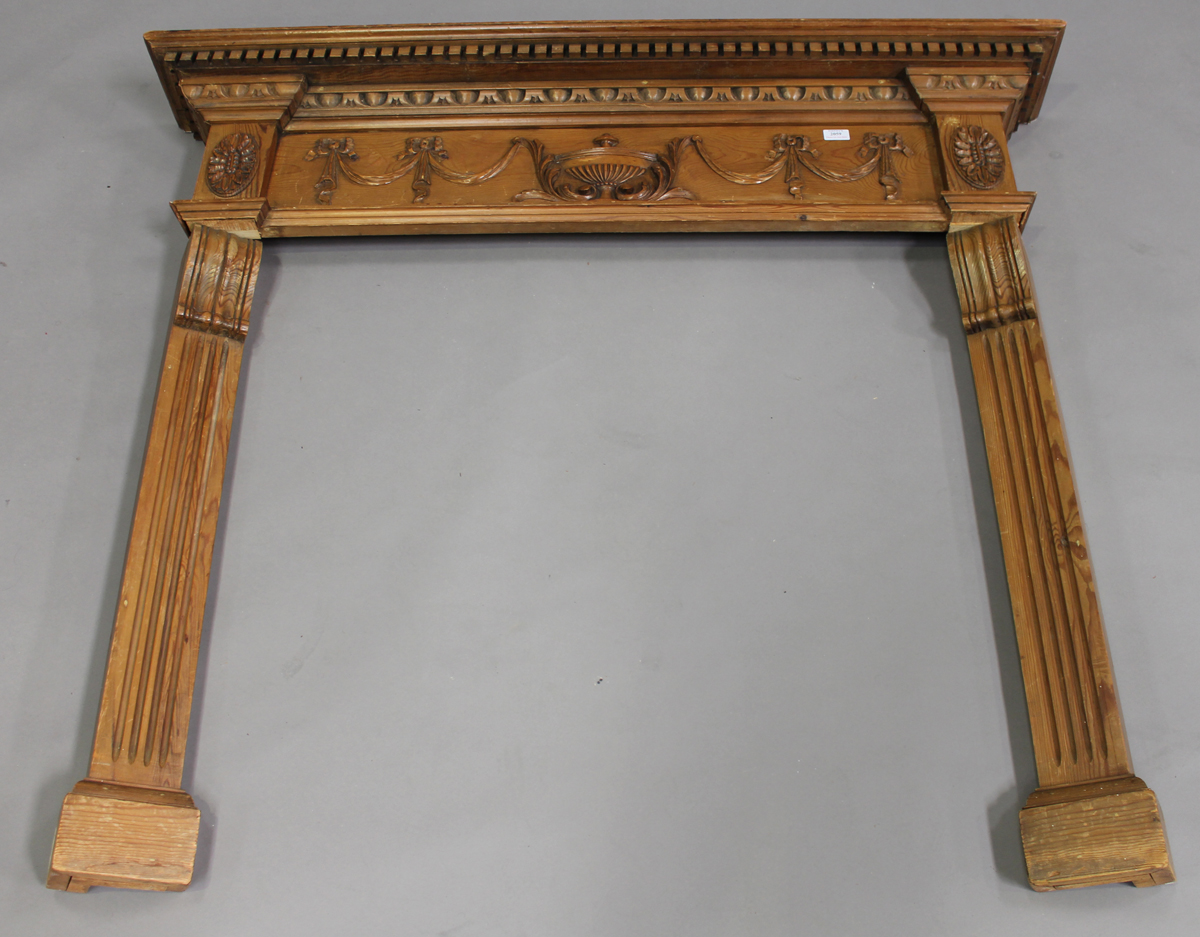 An early 20th century Neoclassical Revival pine fire surround, the frieze carved with central urn,