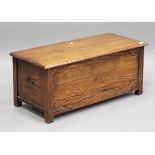 An Art Deco oak coffer, the hinged lid above a carved front, height 46cm, width 106cm, depth 46cm.