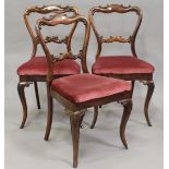 A selection of thirteen Victorian walnut and rosewood spoon back dining chairs, all with carved