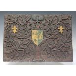 A 19th century carved oak wall plaque, worked in relief with an oak tree centred with an heraldic