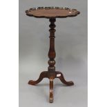 A Victorian mahogany wine table with a petal shaped top, on a turned baluster column and tripod