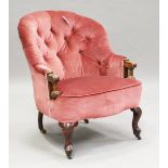 A late Victorian walnut framed tub back armchair, upholstered in buttoned pink velour, on cabriole