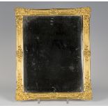 A 19th century cast ormolu frame inset with a bevelled plate mirror, finely cast with scrolls and