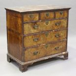 A George I walnut chest of three short and three long oak-lined drawers, all with feather banded