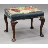 An early 20th century Queen Anne style walnut stool, raised on shell carved cabriole legs and pad