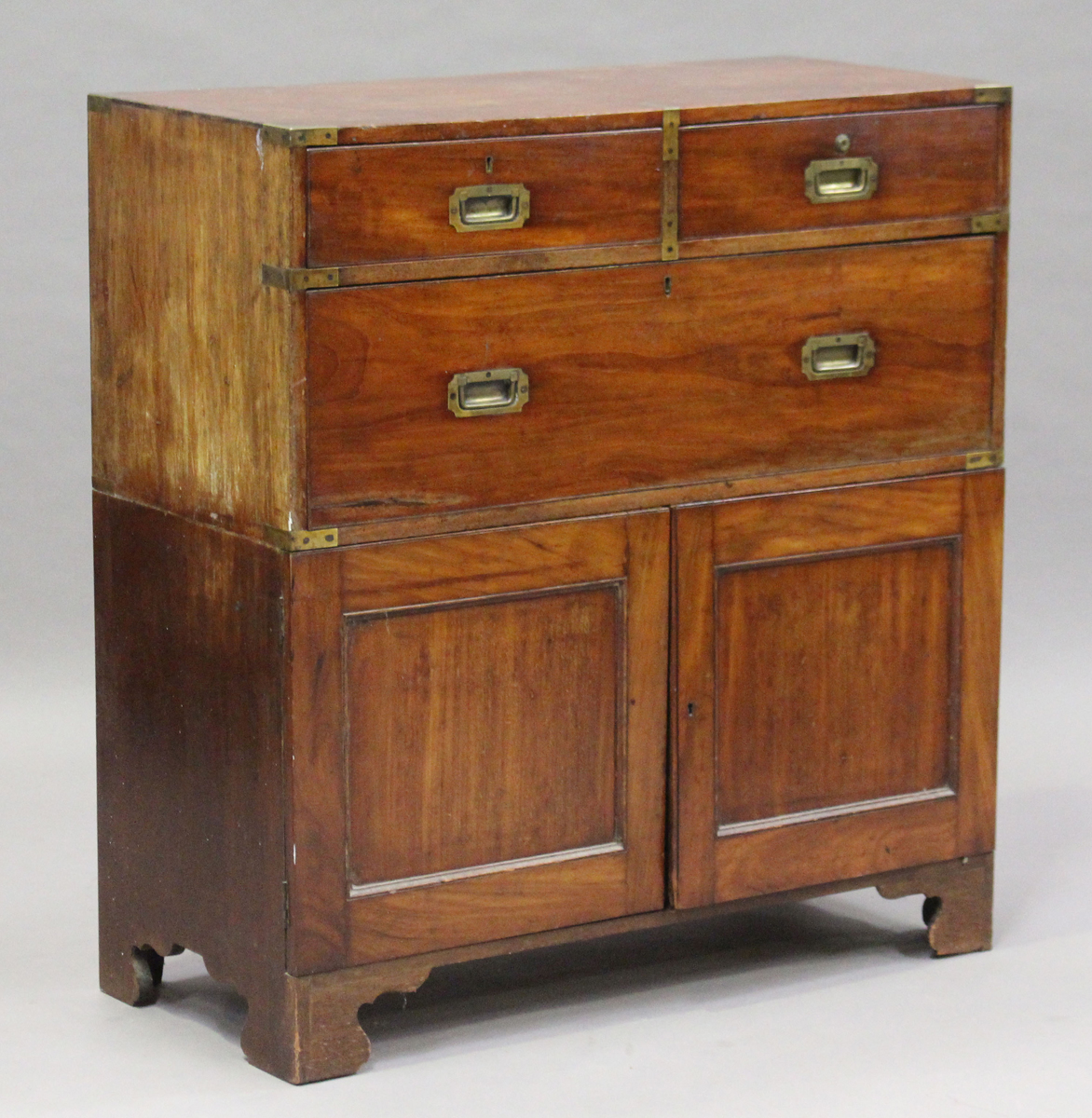 An early Victorian teak and brass mounted campaign chest top section, raised on an associated