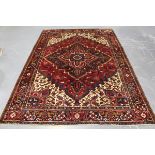 A Heriz carpet, North-west Persia, mid-20th century, the red field with a bold hooked medallion,