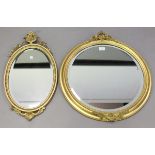 An Edwardian gilt composition circular wall mirror, the beaded frame with foliate crestings,