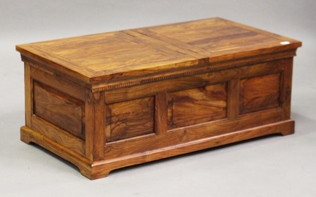 A modern hardwood coffee table trunk, the top fitted with two hinged lids, height 43cm, width 111cm,