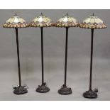 A set of four modern Tiffany style lamp standards with leaded glass shades and patinated metal