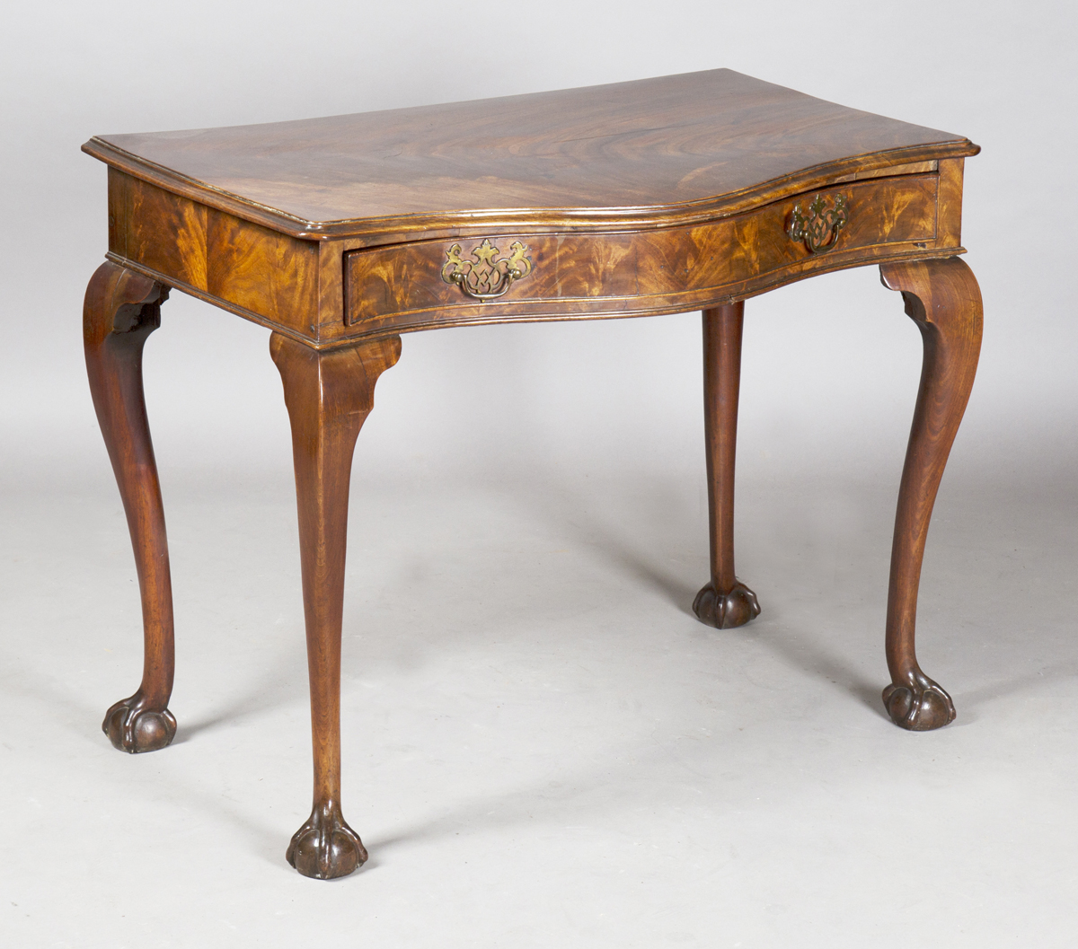 A George III figured mahogany serpentine-fronted side table, fitted with a single oak-lined