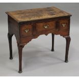 An early 18th century provincial oak lowboy, fitted with three crossbanded drawers, on tapering