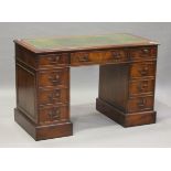 A late 20th century reproduction mahogany twin pedestal desk, the top inset with gilt-tooled green